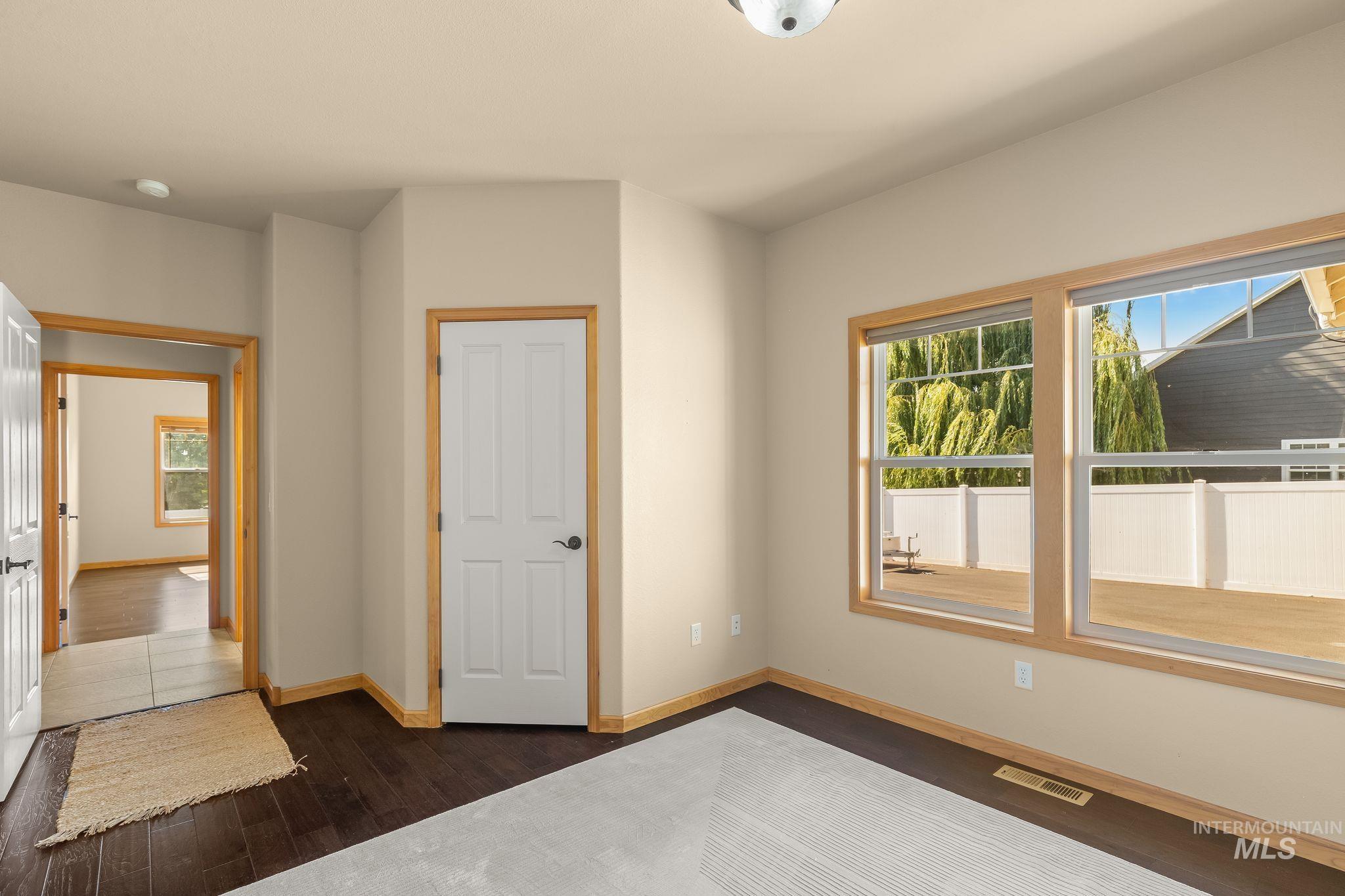Interior room with dark wood-finish flooring and light-toned walls