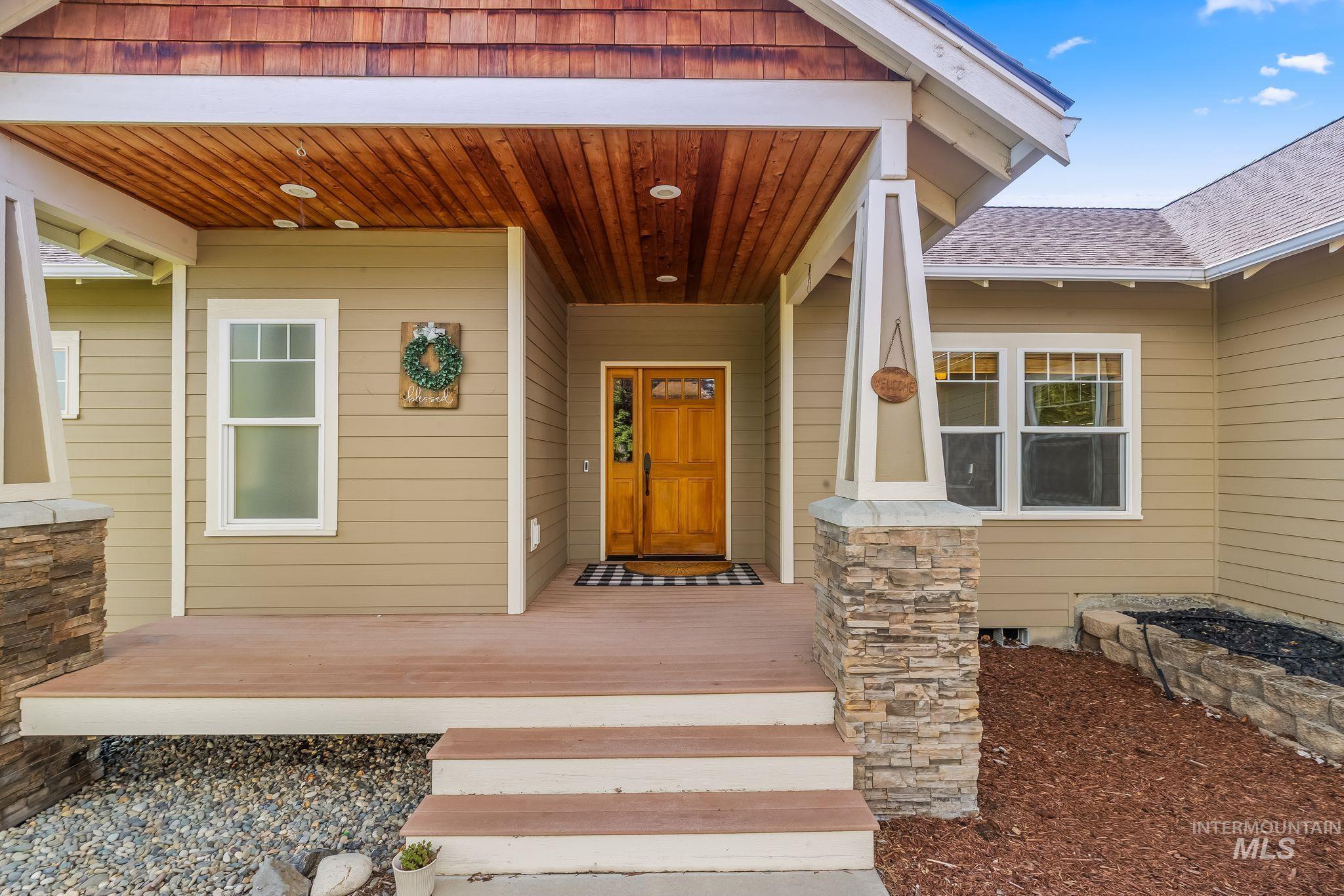 Covered front porch with wood-finish ceiling and recessed lighting