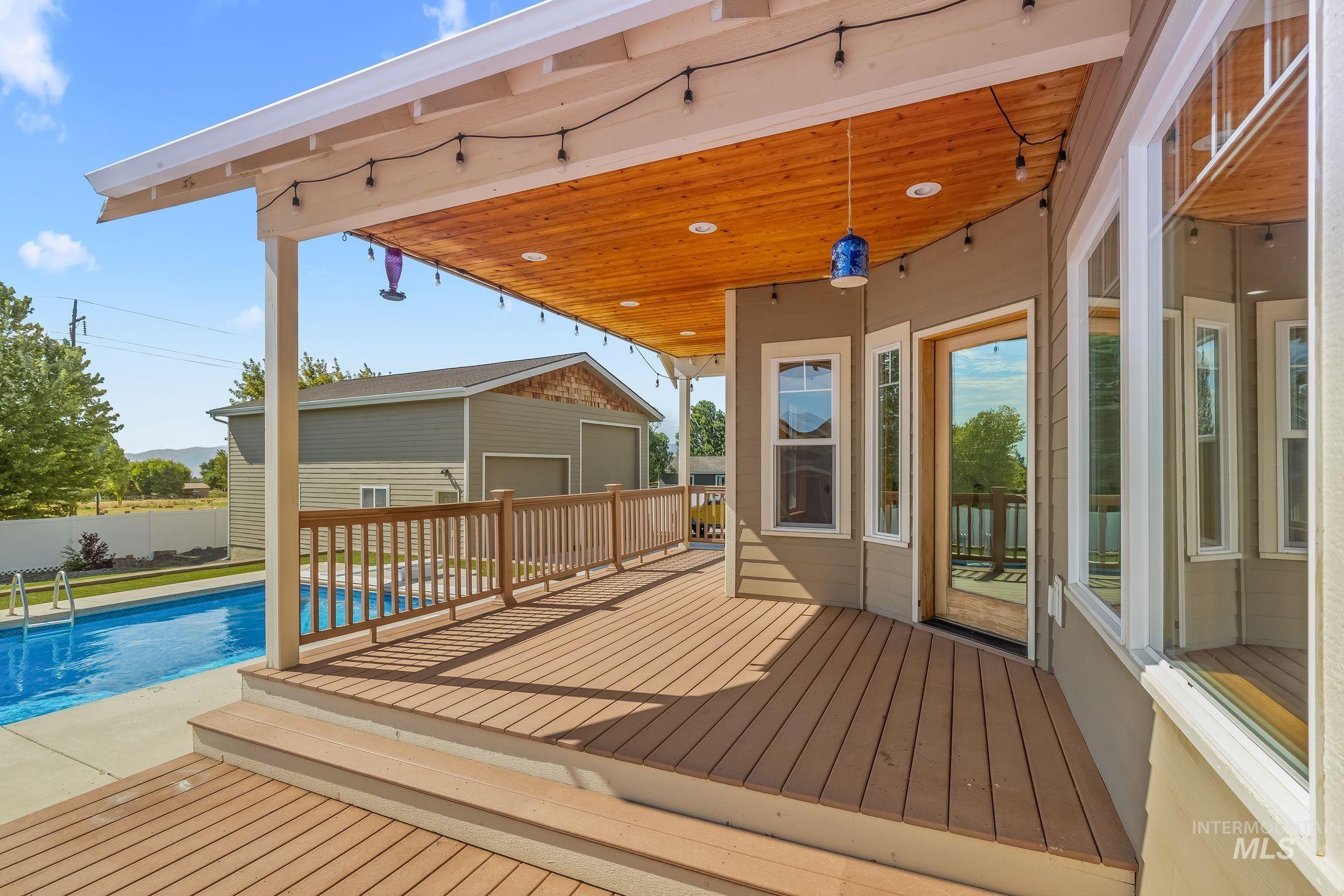Spacious covered deck featuring a natural wood-finish ceiling, a multi-level composite deck, and a clear railing