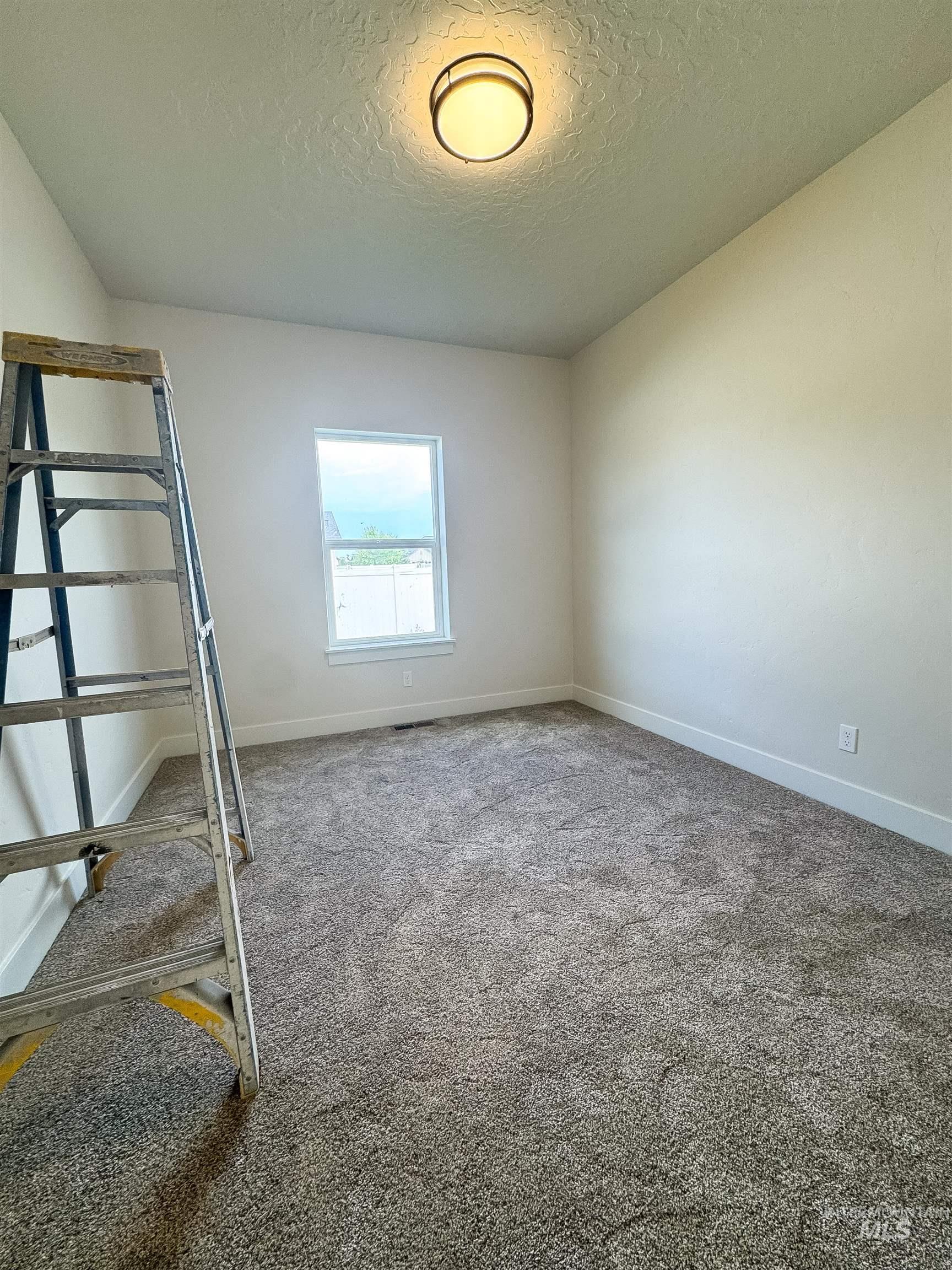Unfurnished bedroom featuring a textured ceiling and carpet floors