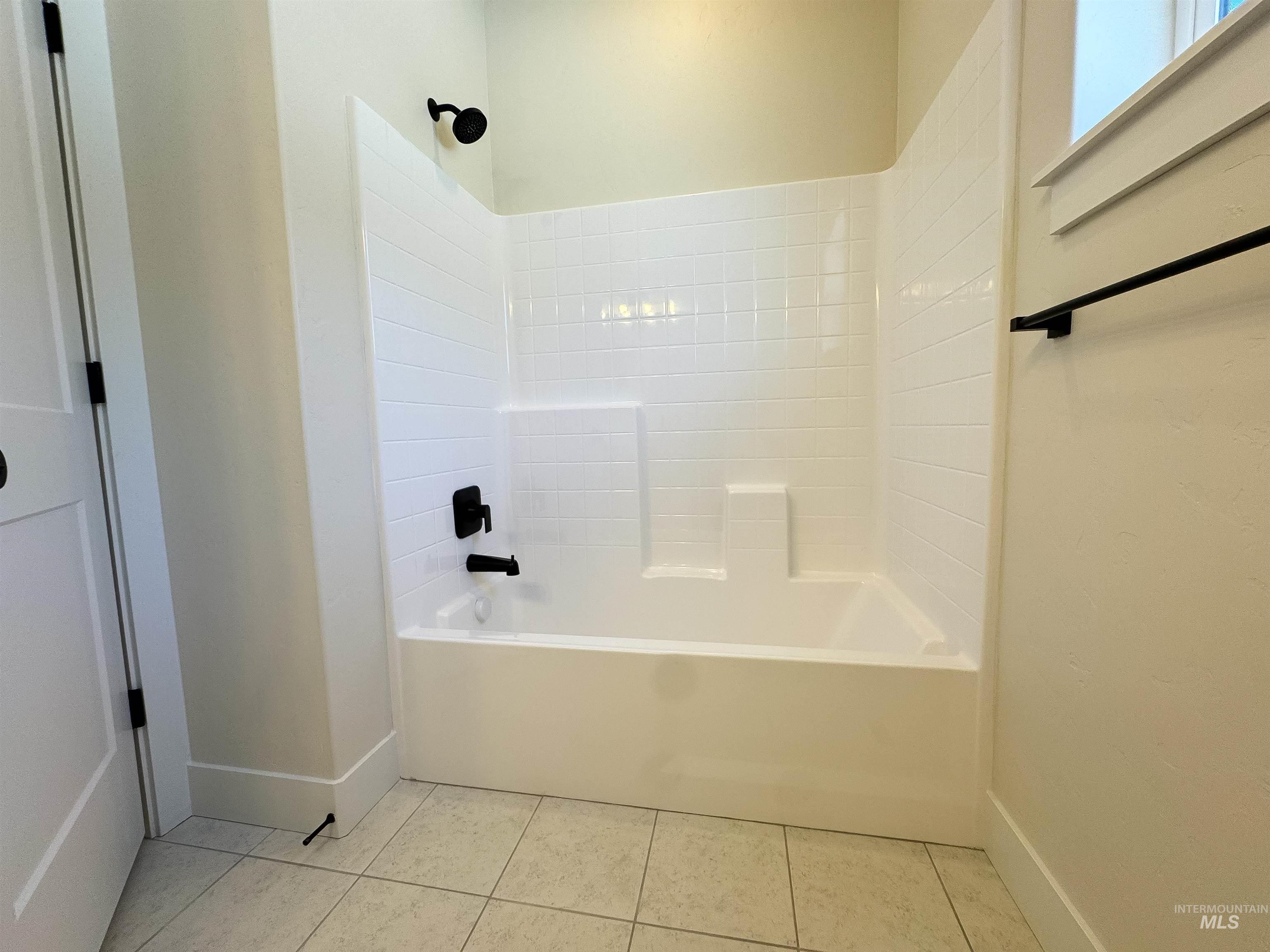 Full bathroom with tile patterned floors and shower / tub combination