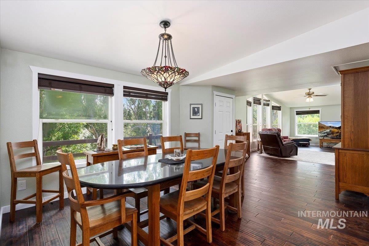 Dining area featuring dark wood-type flooring and ceiling fan
