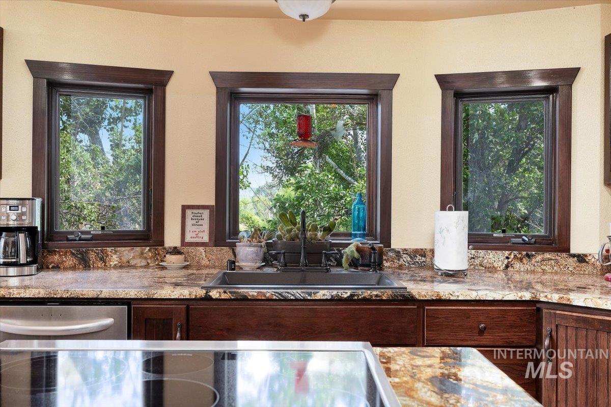 Kitchen with black electric stovetop and stainless steel dishwasher
