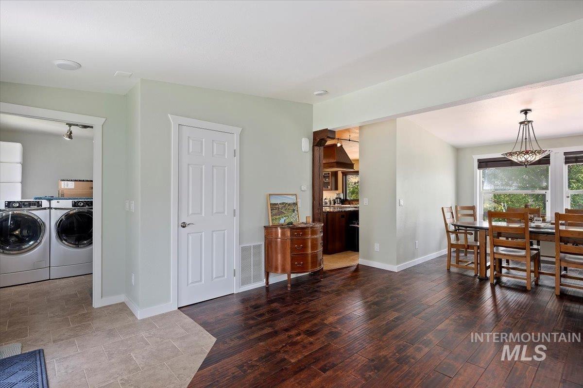 Dining space with separate washer and dryer and wood finished floors