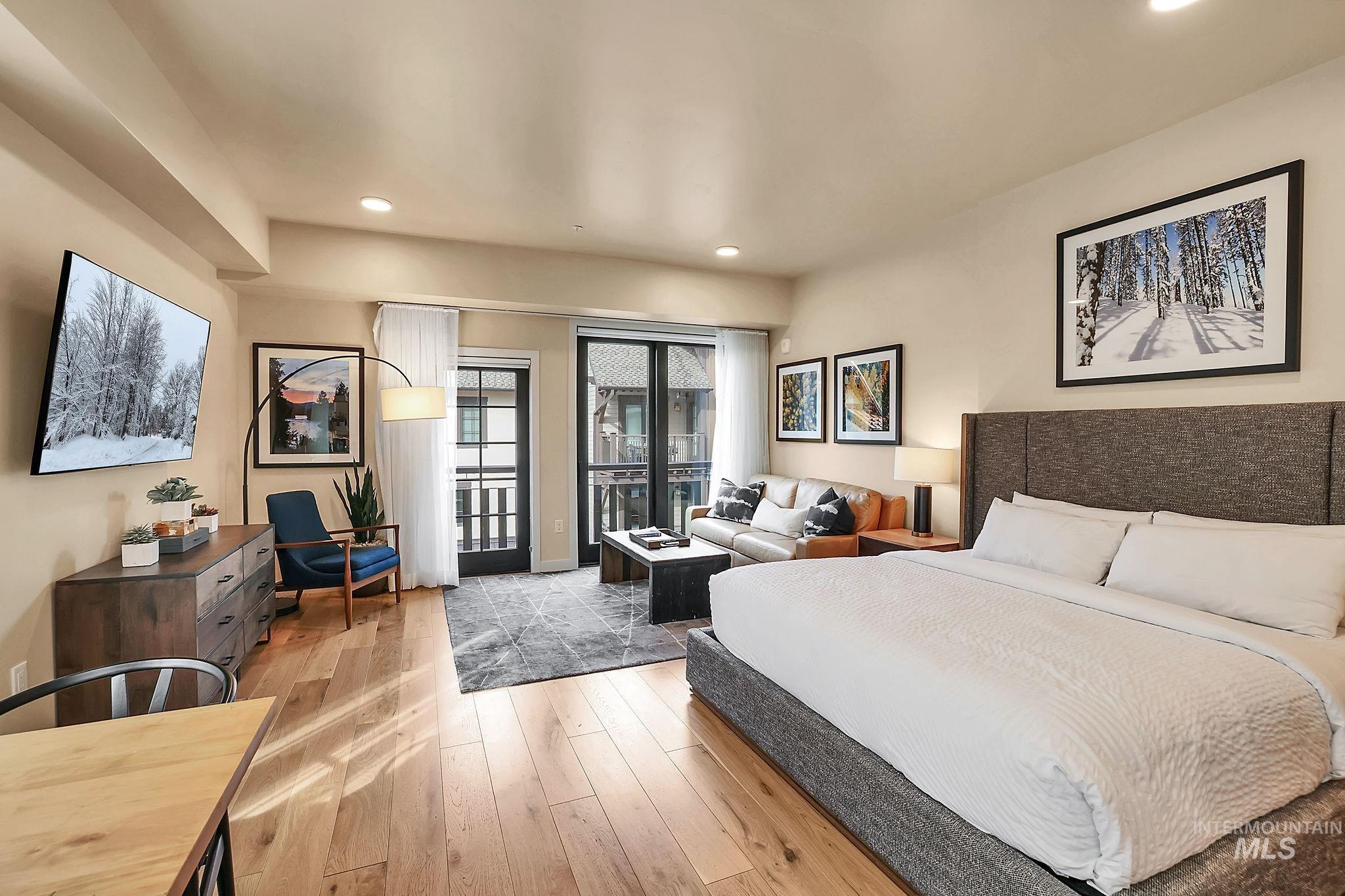 Bedroom with access to exterior, light wood-style flooring, and recessed lighting