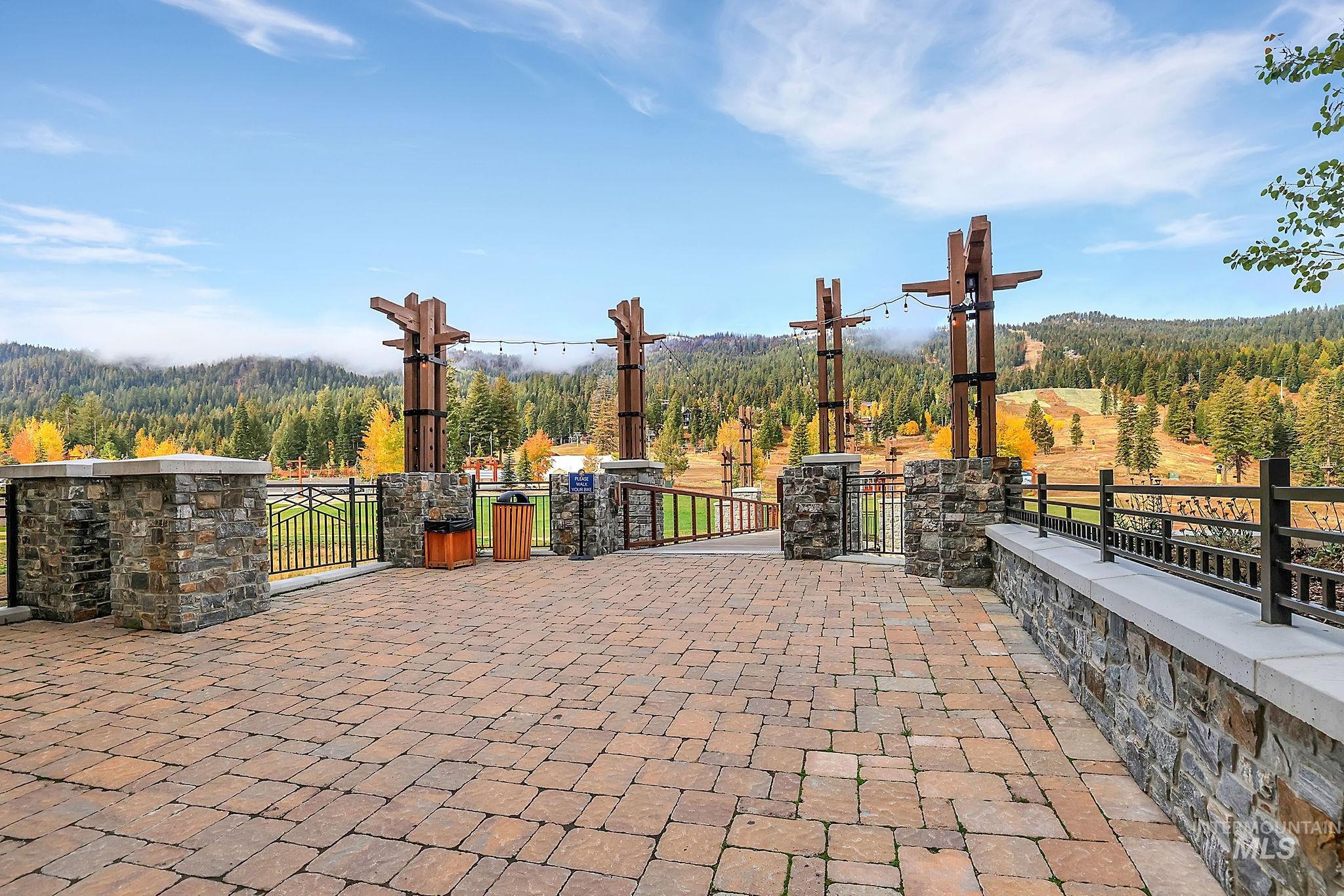 View of patio with a wooded view and a gate