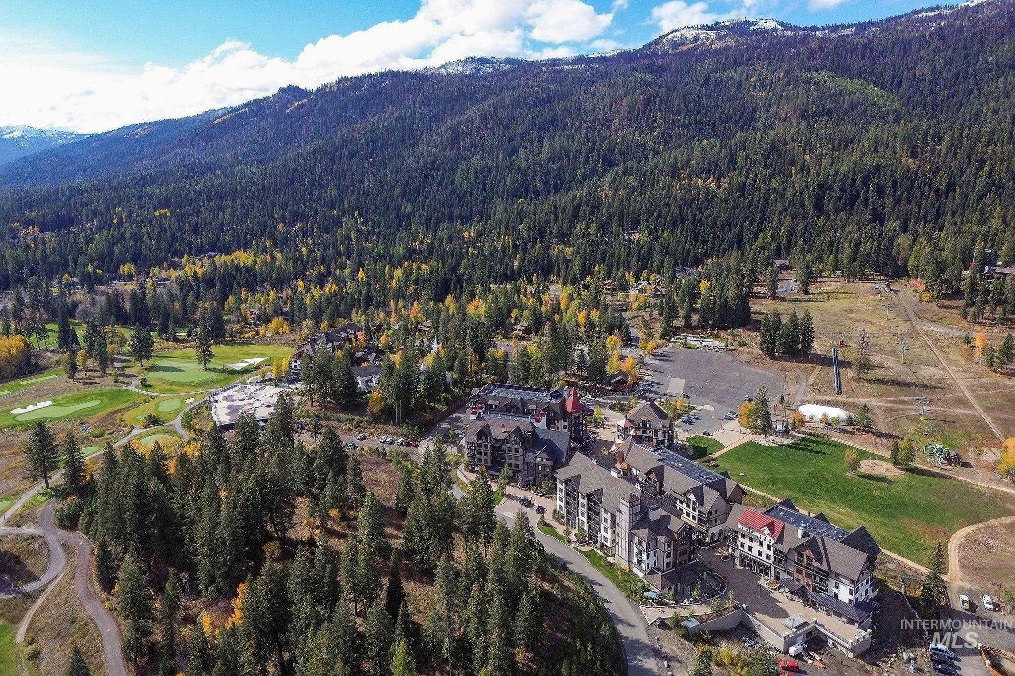 Aerial view of property's location with mountains and a local golf course