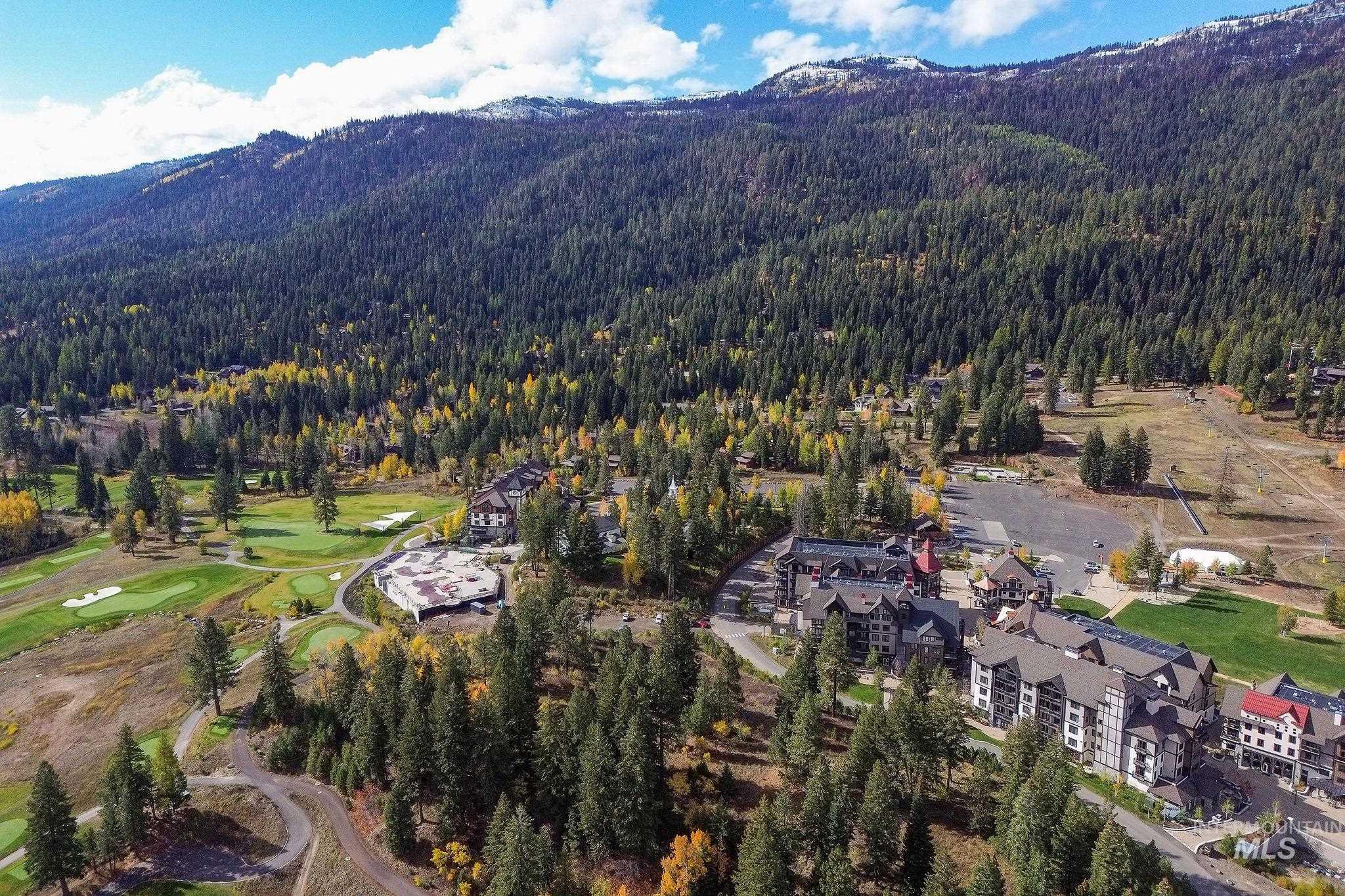 Aerial view of property's location with a mountainous background and a golf course