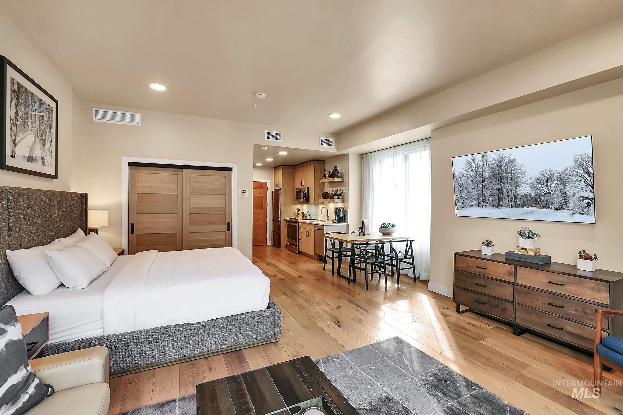 Bedroom featuring light wood-style flooring, recessed lighting, a closet, and high end fridge