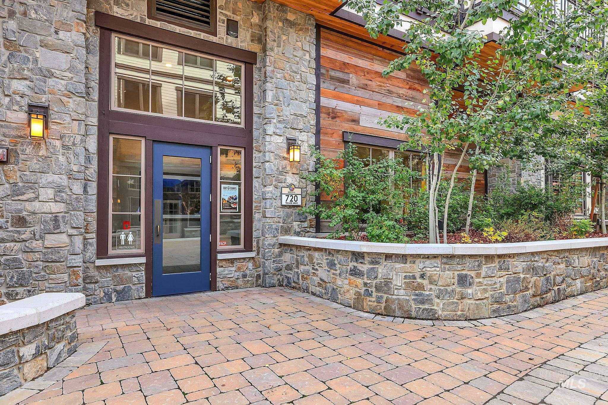 Doorway to property featuring stone siding and a patio area