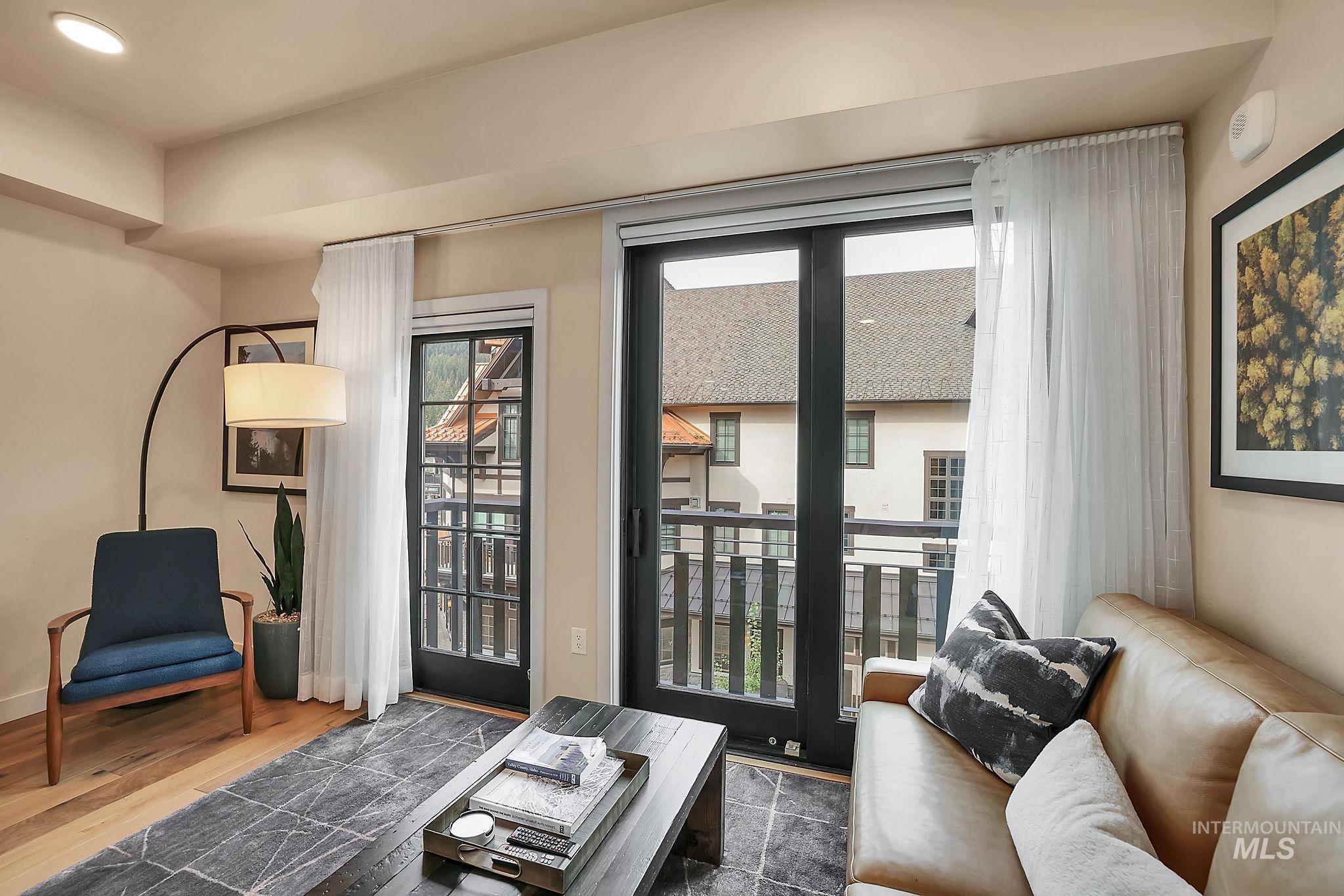 Living area with healthy amount of natural light, wood finished floors, and recessed lighting