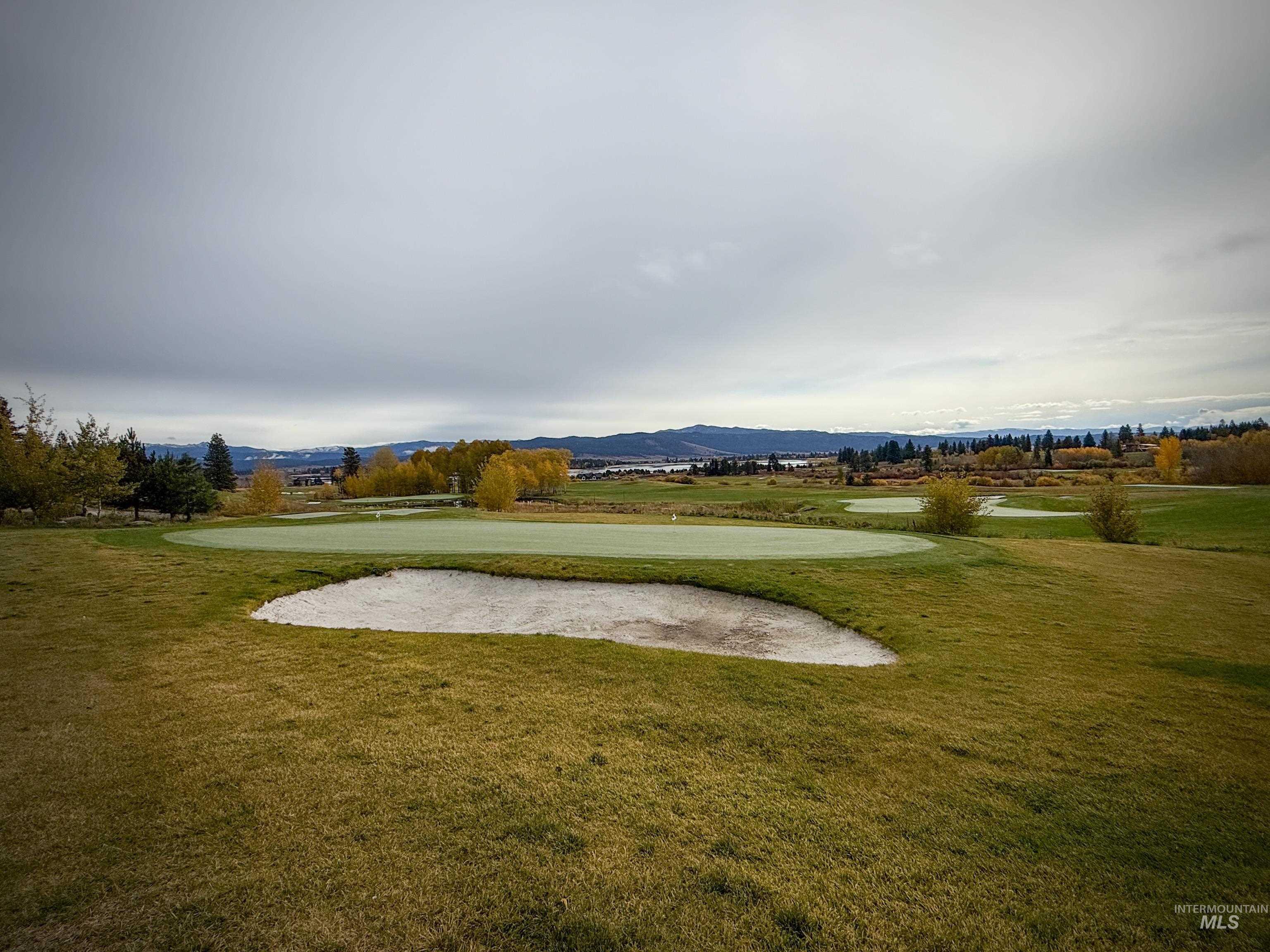 Surrounding community featuring a lawn, a mountain view, and golf course view
