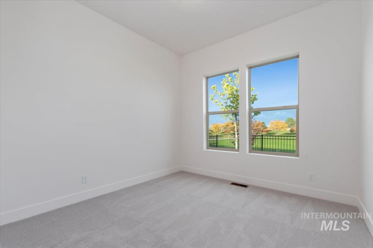 Unfurnished room with light colored carpet and baseboards