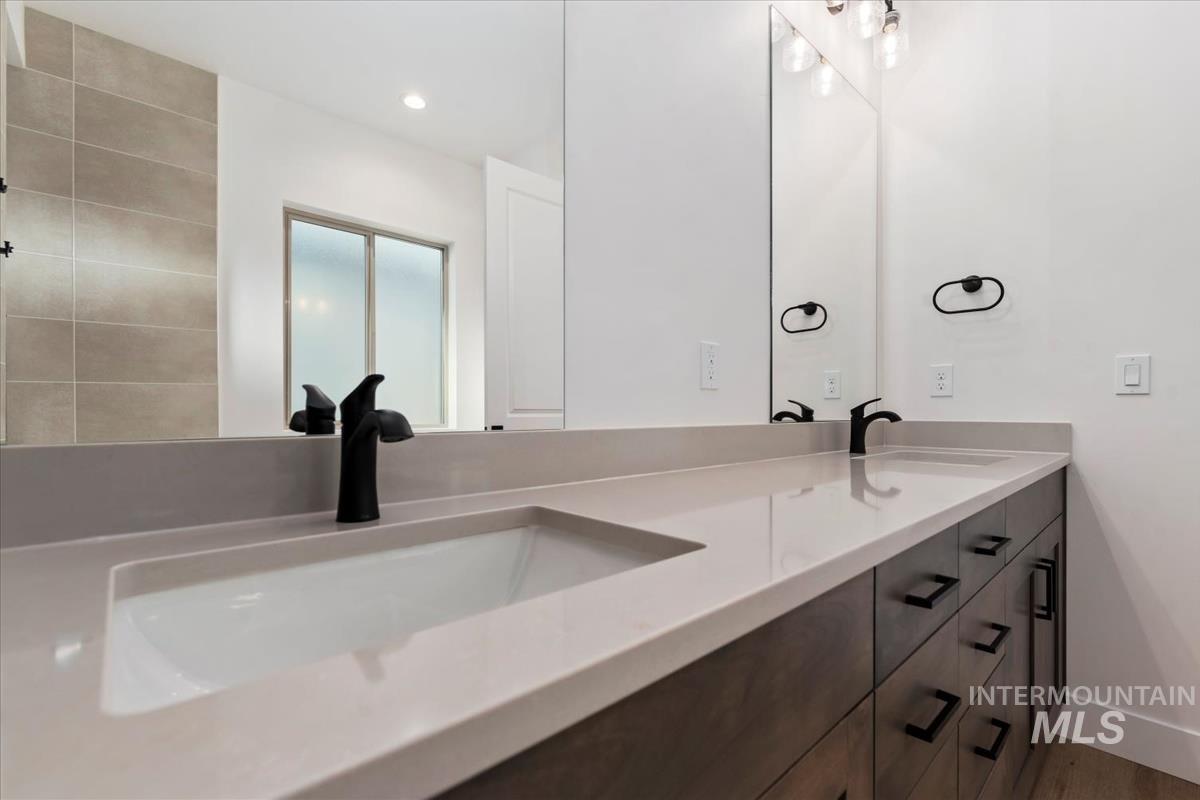 Full bathroom featuring double vanity, light wood-type flooring, and recessed lighting