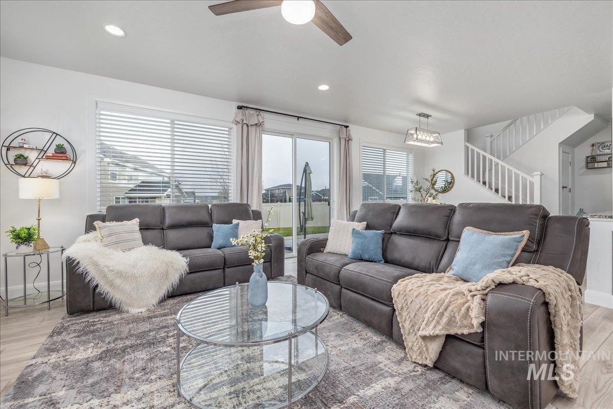 Living room featuring light wood-style flooring, stairway, healthy amount of natural light, and recessed lighting