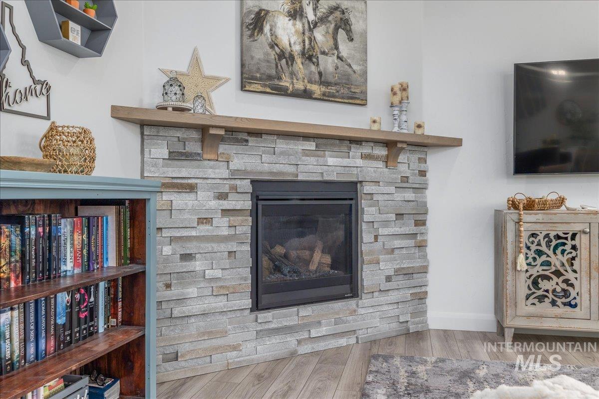Detailed view of wood finished floors and a stone fireplace