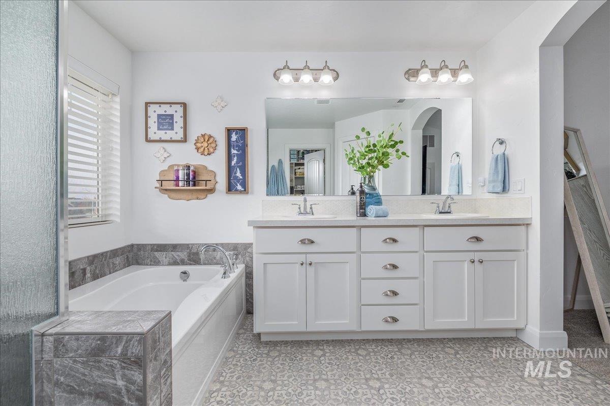 Full bathroom with double vanity and a garden tub