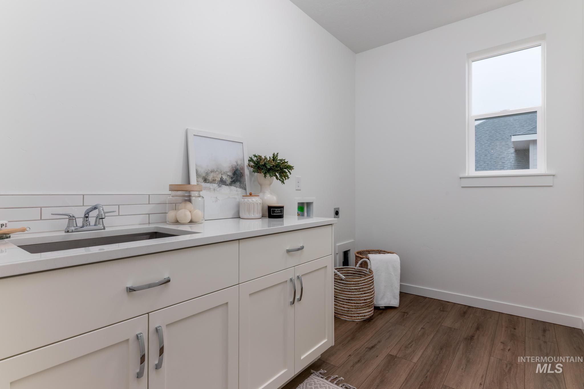 Laundry area featuring dark wood-style floors, washer hookup, cabinet space, and hookup for an electric dryer