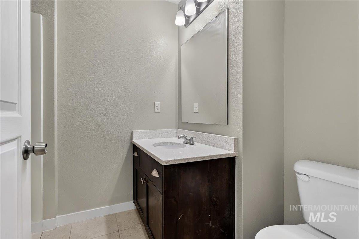 Bathroom vanity with an undermount sink, a light-colored countertop, and a dark wood-finish cabinet