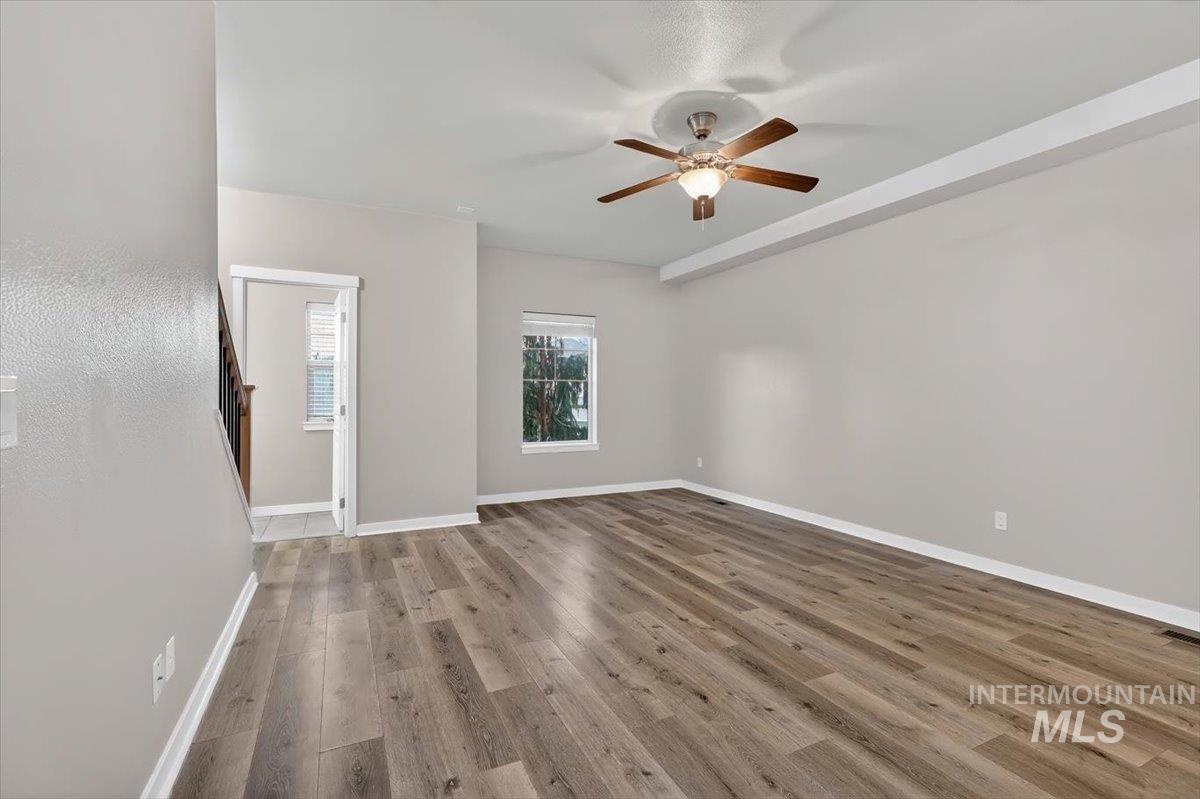 Spacious living area featuring wood-finish flooring, neutral wall tones, and recessed ceiling details