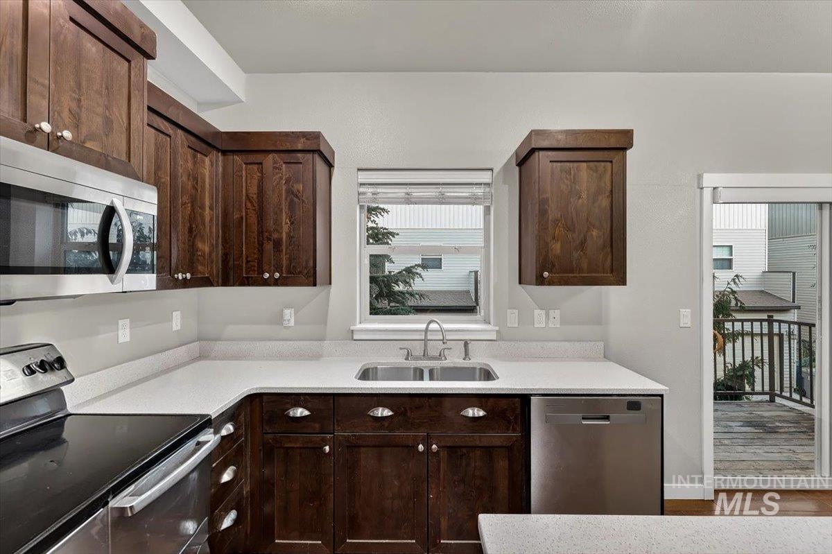 Kitchen featuring wood-finish cabinetry, stainless steel appliances, and light-toned countertops
