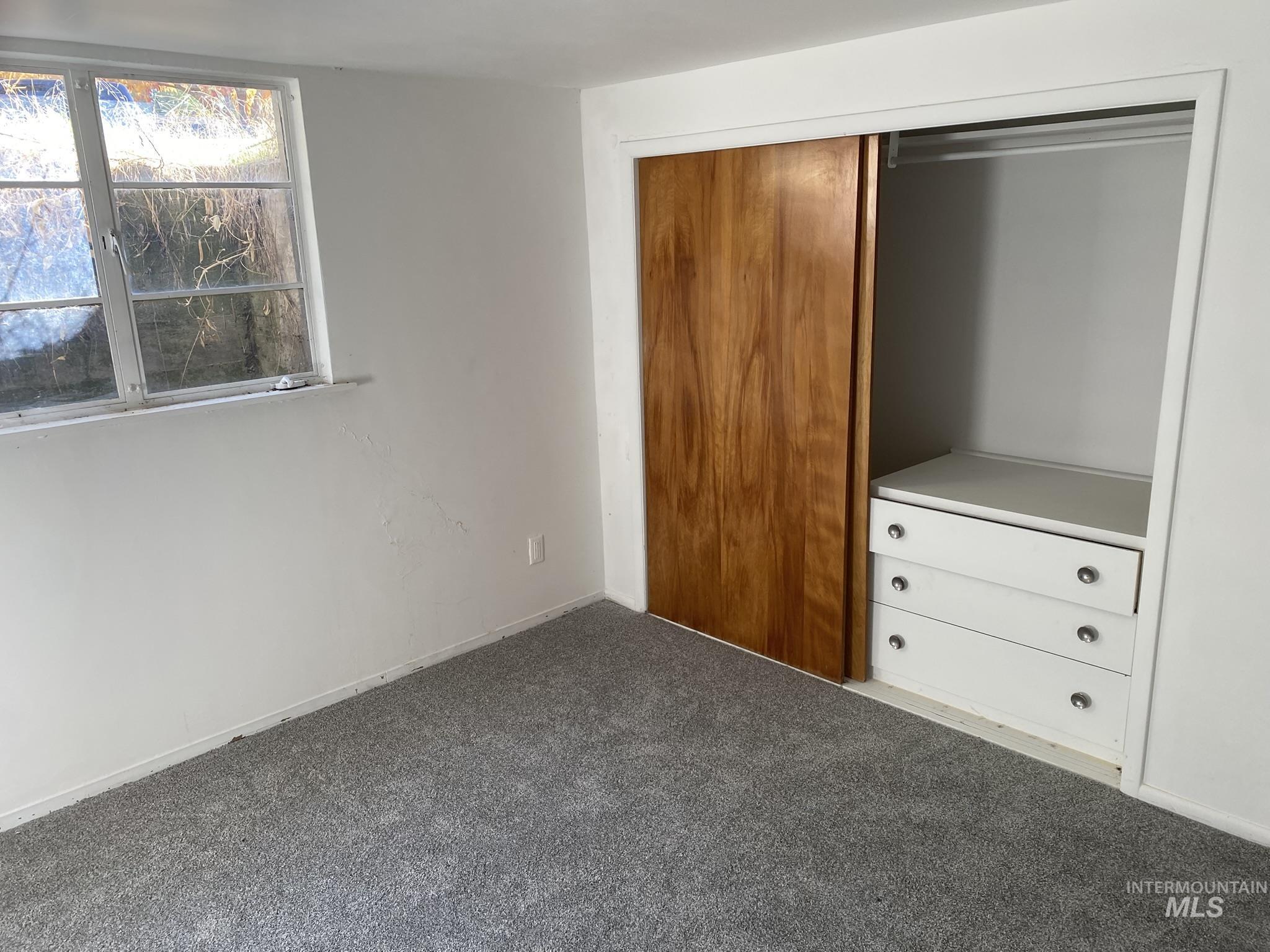 Unfurnished bedroom with carpet and a closet