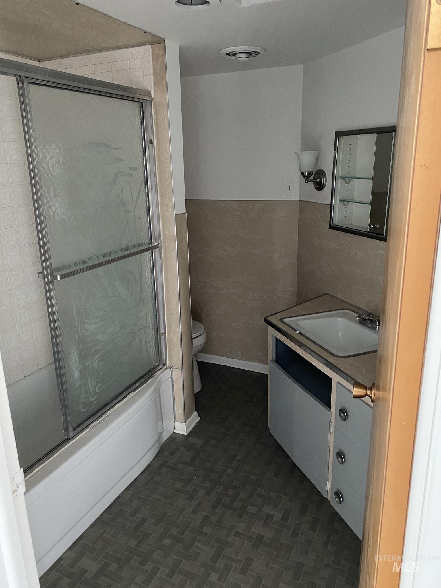 Full bathroom with vanity and combined bath / shower with glass door