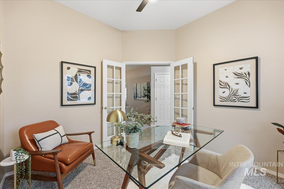 Carpeted office with french doors and a ceiling fan