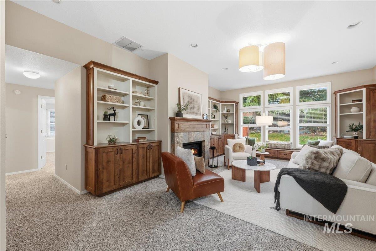 Sitting room featuring light carpet, plenty of natural light, and a fireplace
