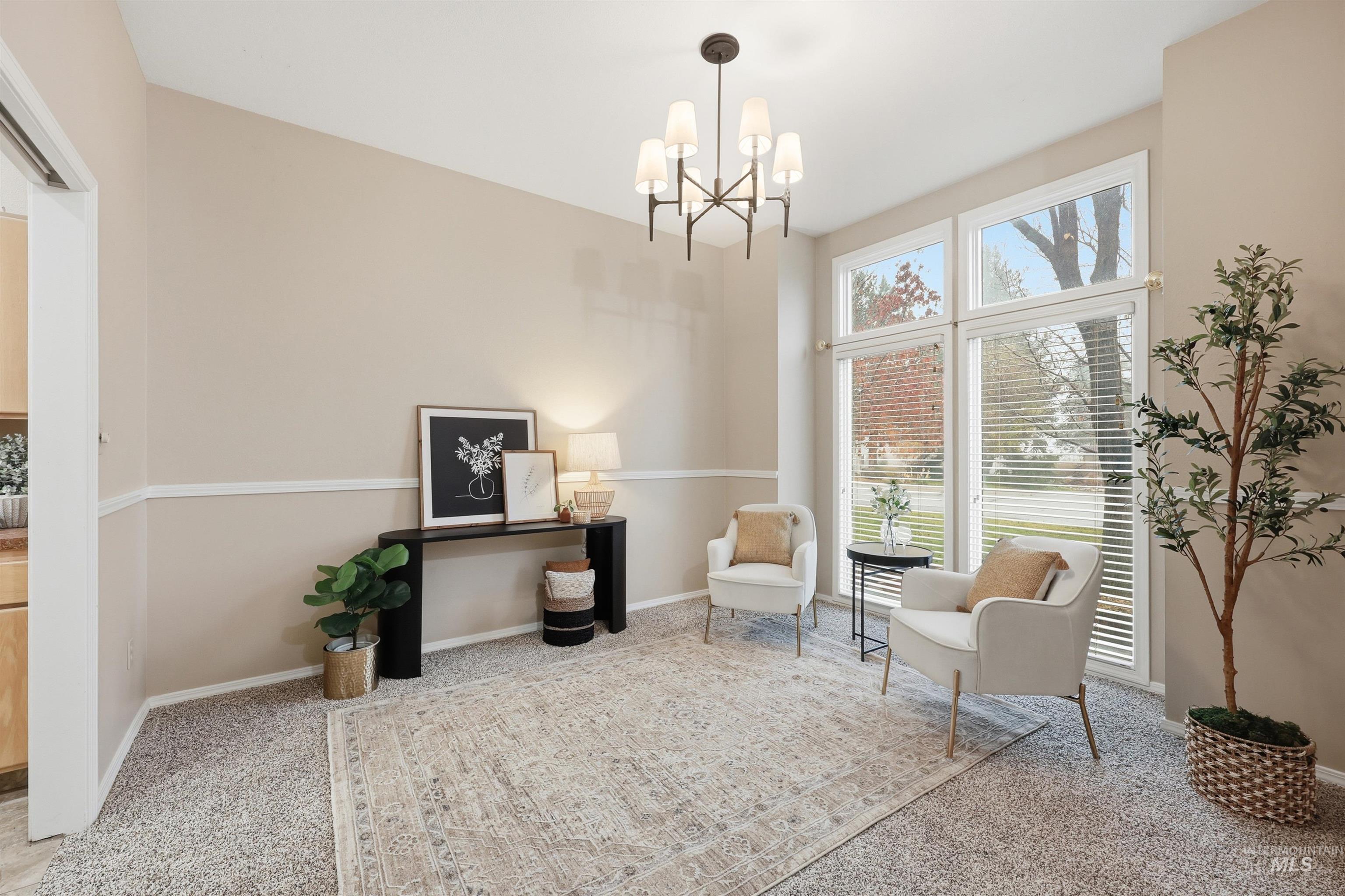 Sitting room featuring light colored carpet and a chandelier