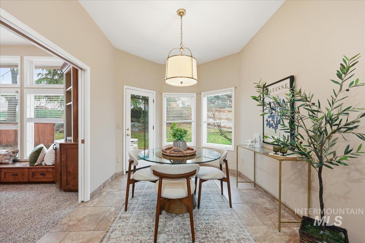 Dining area with plenty of natural light, stone tile flooring, and light colored carpet