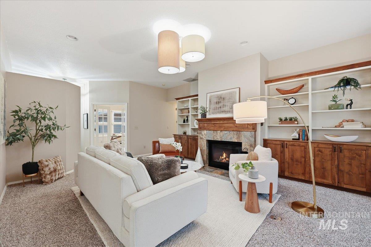 Carpeted living area featuring a fireplace and built in shelves
