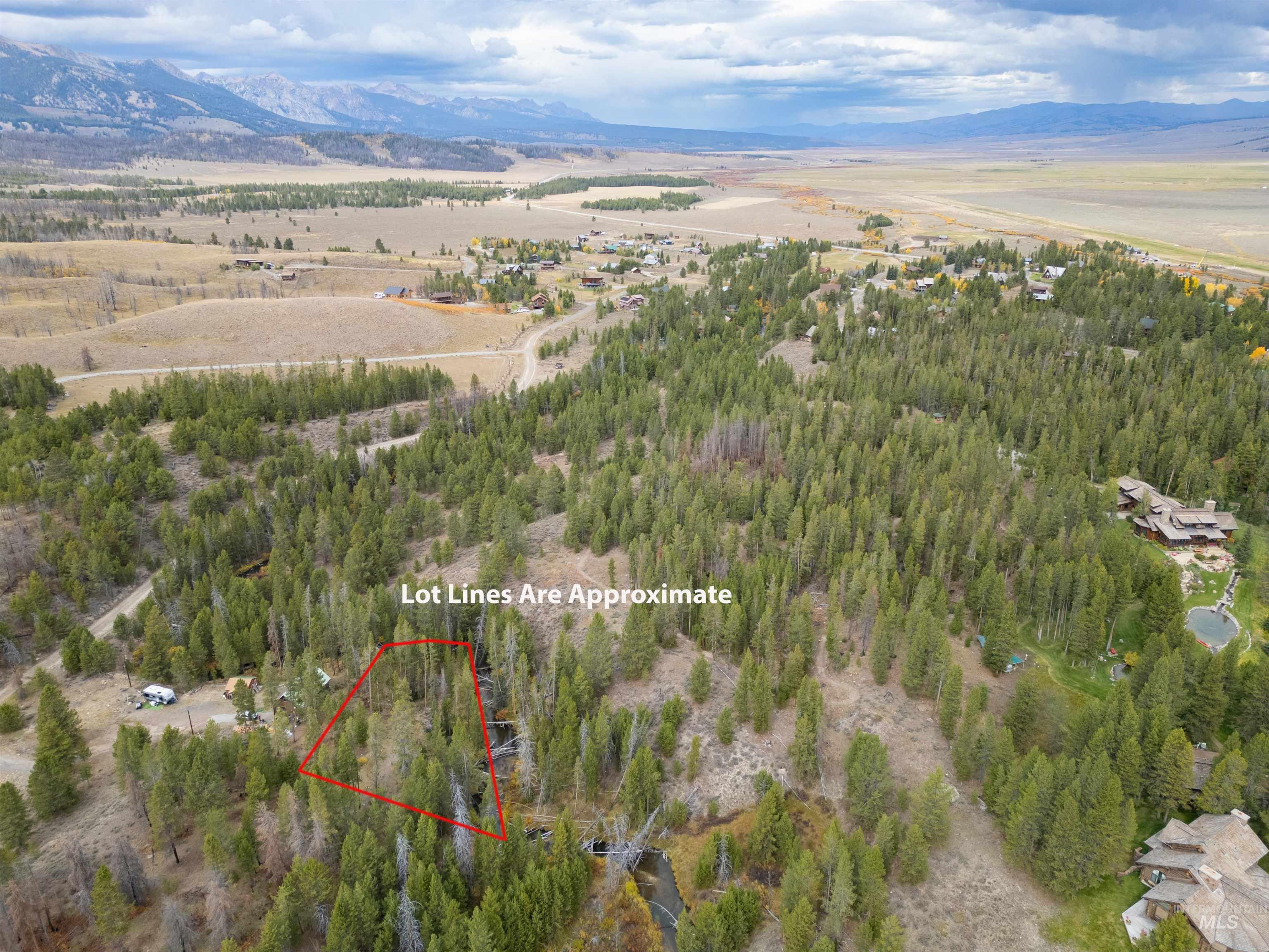 Aerial view of property's location featuring a mountainous background and property parcel outlined