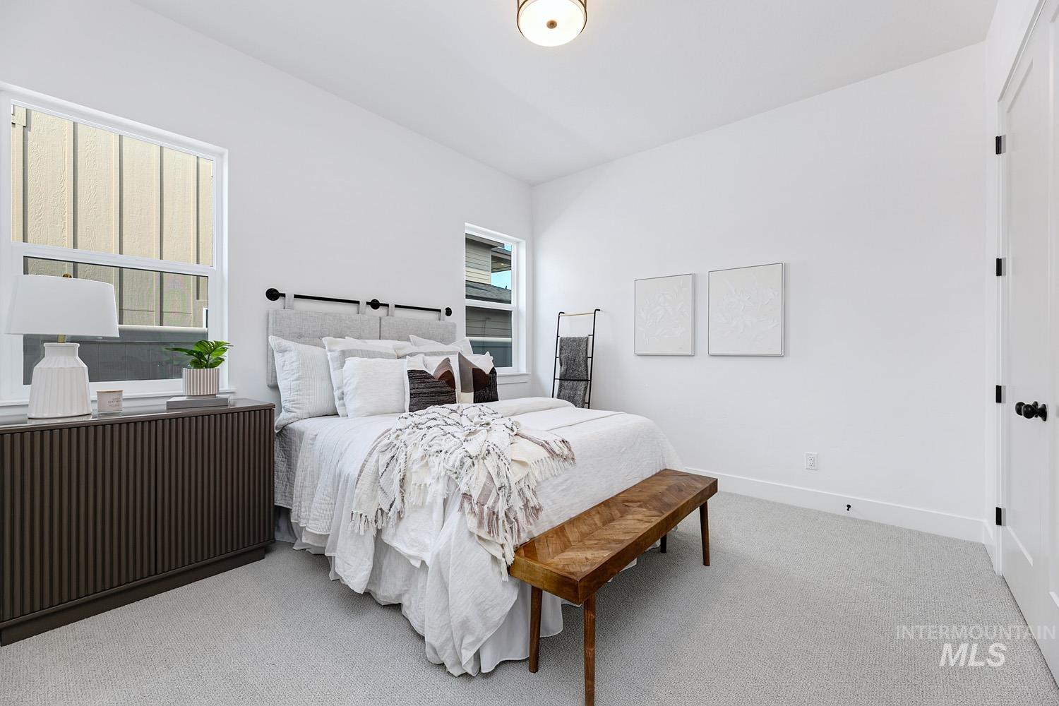 Carpeted bedroom with multiple windows