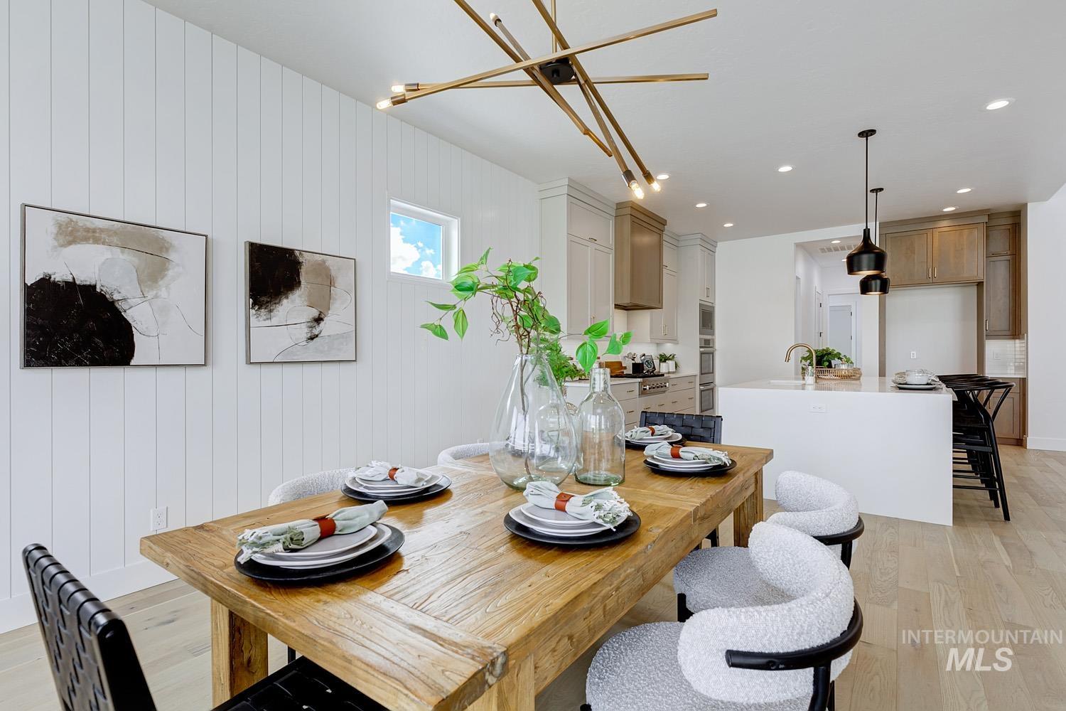 Dining room with light wood-style flooring, recessed lighting, and wood walls
