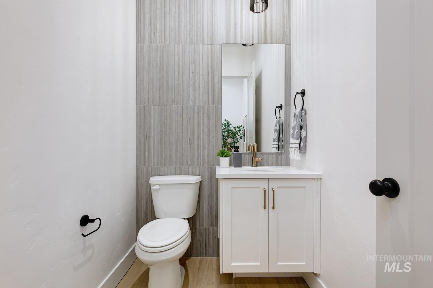 Half bathroom featuring vanity and tile walls
