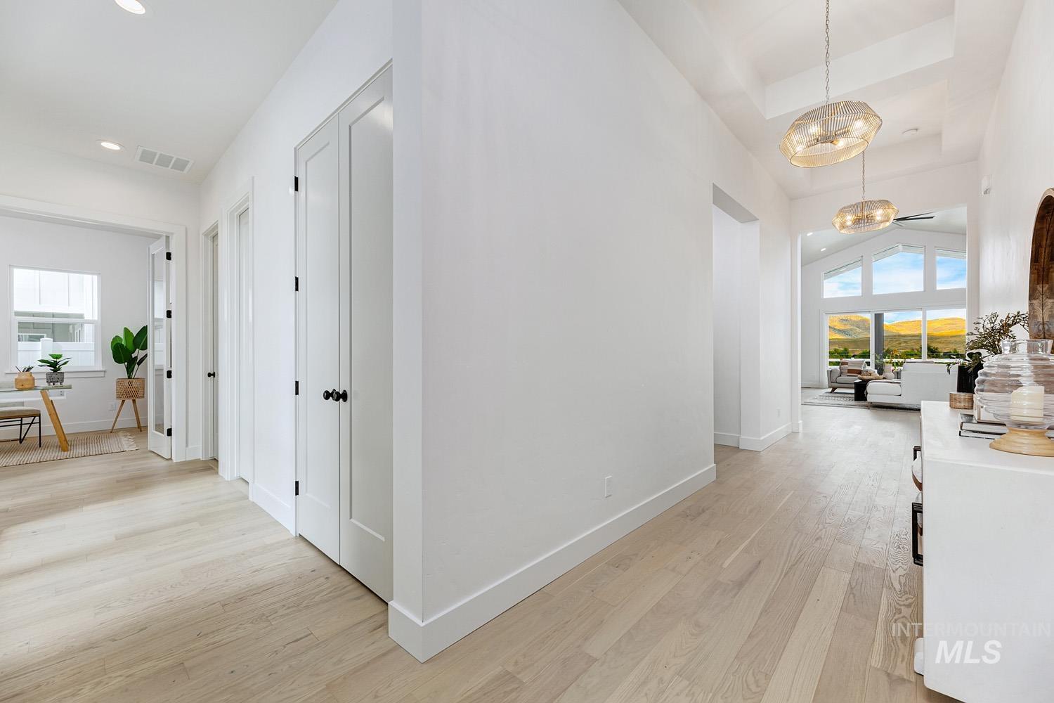 Hallway featuring healthy amount of natural light, light wood-style floors, and recessed lighting