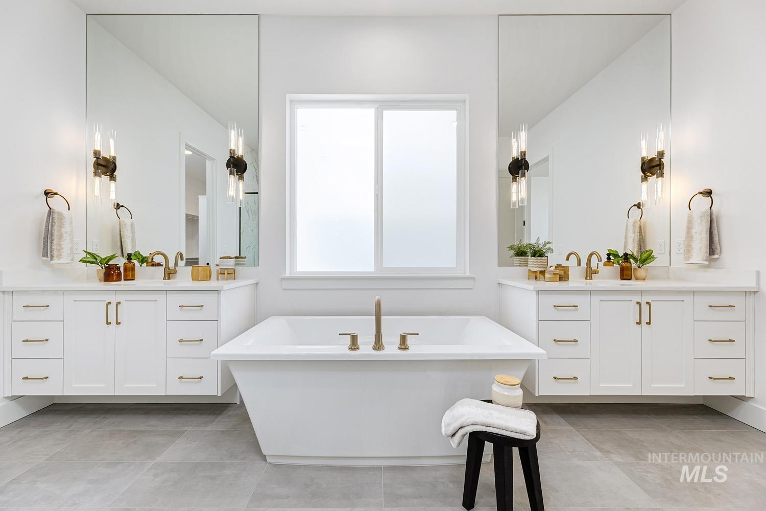 Bathroom with two vanities, a soaking tub, and light tile patterned floors