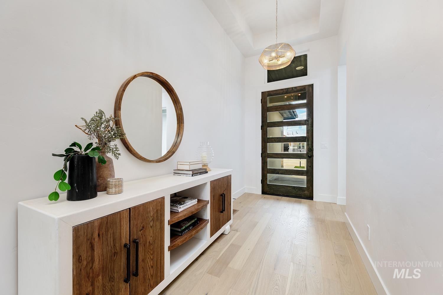 Foyer entrance featuring light wood-style flooring and a towering ceiling