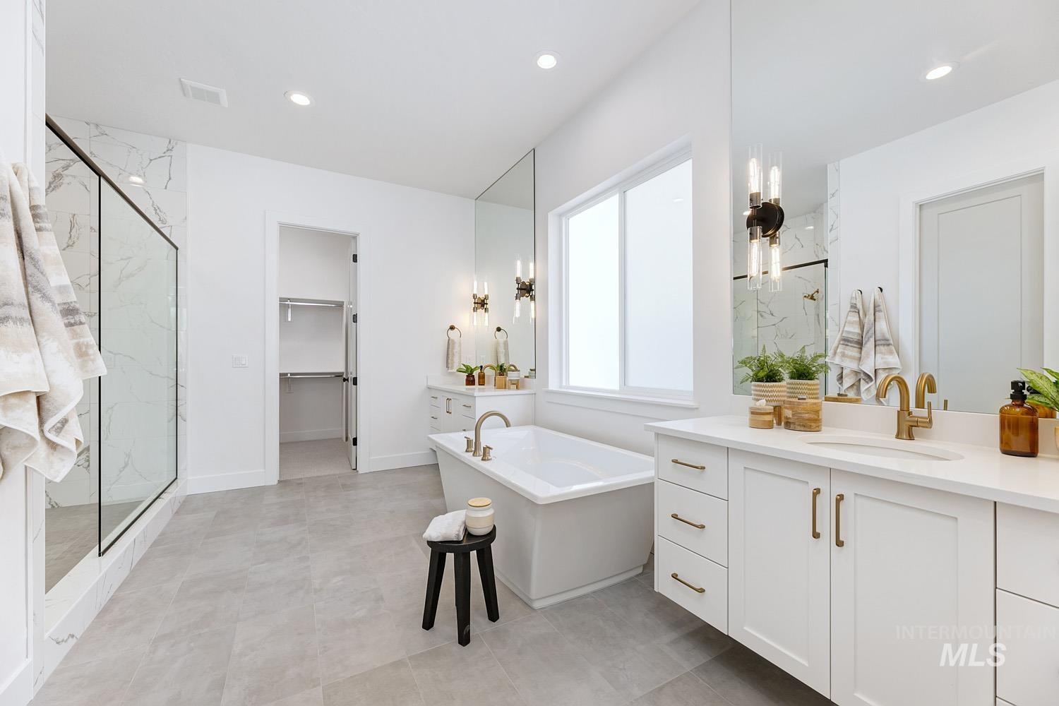Full bath with a marble finish shower, a freestanding tub, a spacious closet, vanity, and recessed lighting