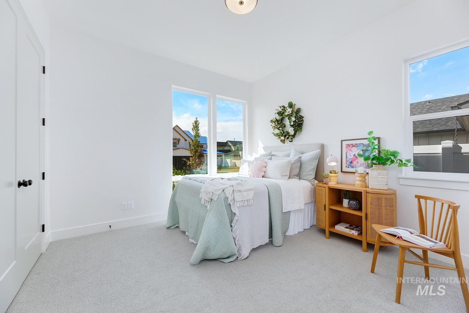 Bedroom with light colored carpet and baseboards