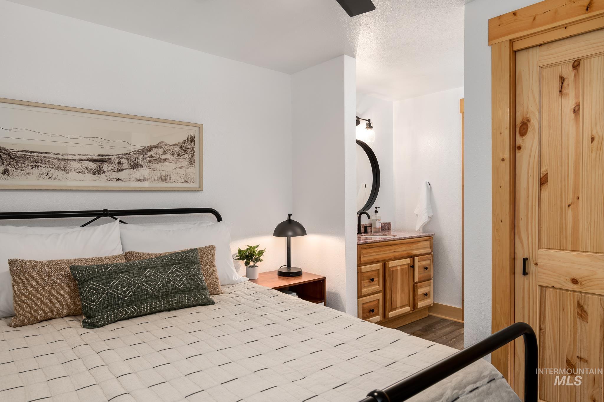 Bedroom featuring a metal bed frame, light wood-finish flooring, and a natural wood door