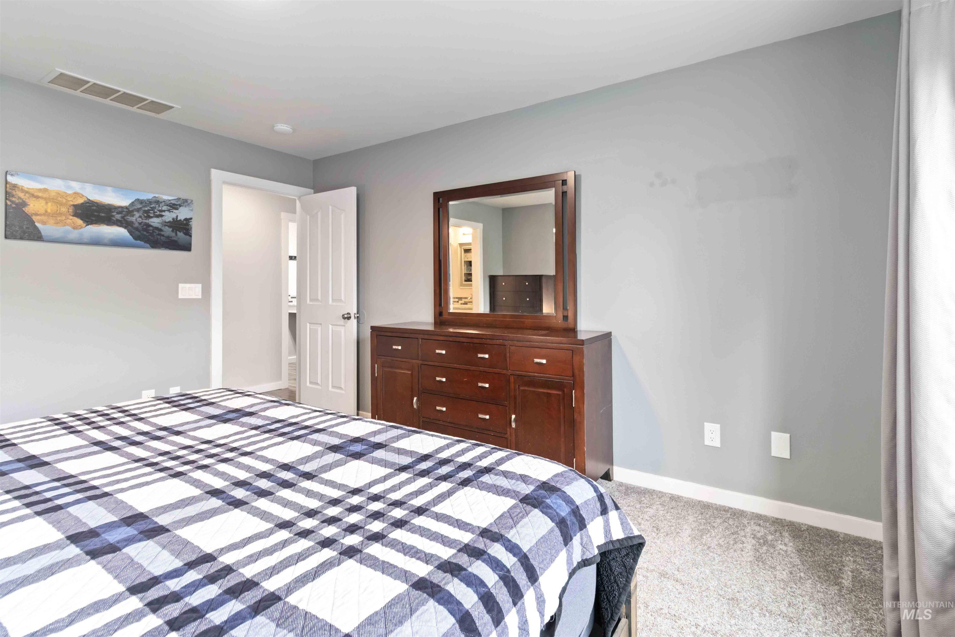 Bedroom featuring light carpet and baseboards