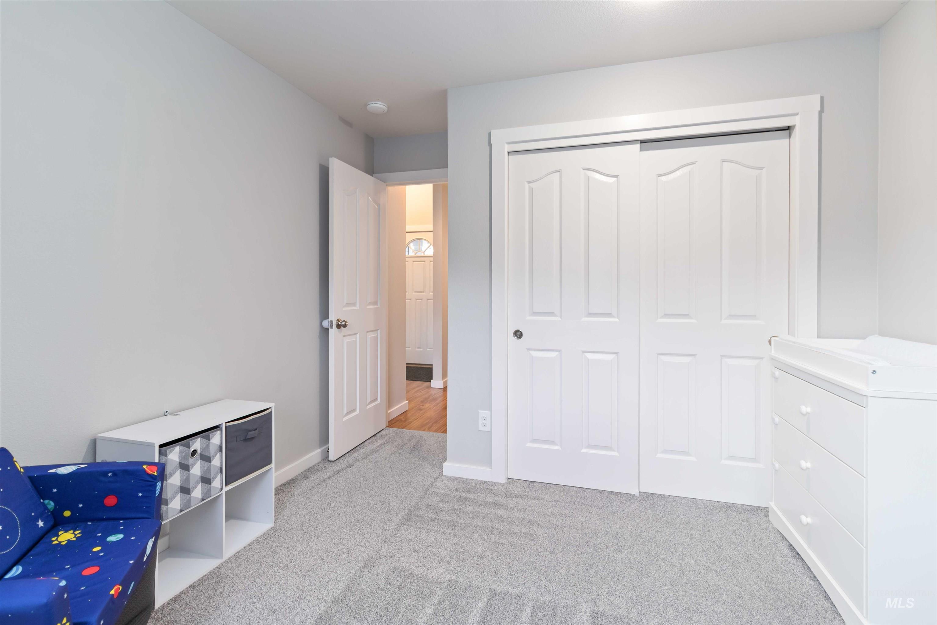Bedroom featuring light carpet and a closet