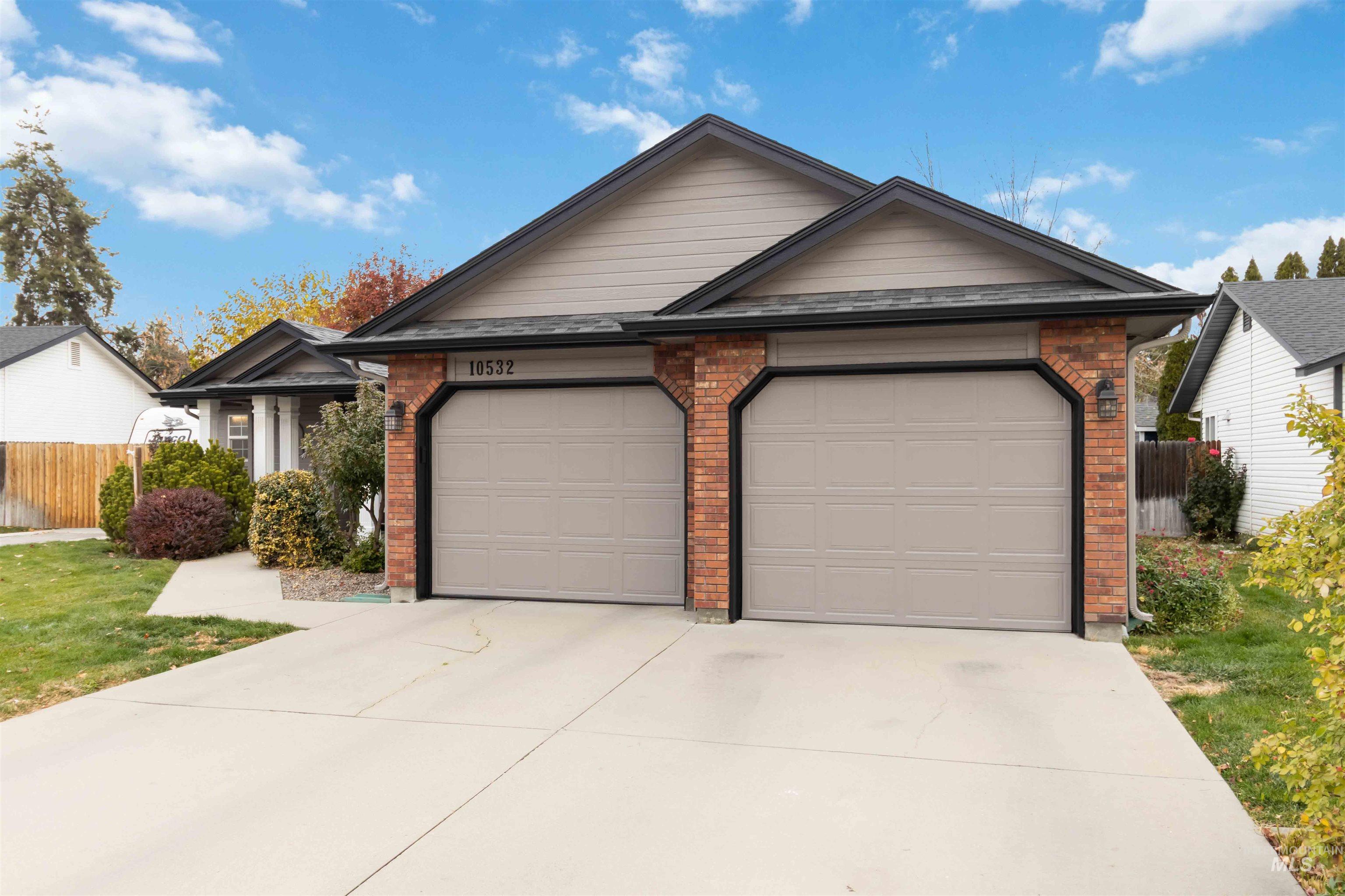 Single story home featuring brick siding, concrete driveway, and a garage