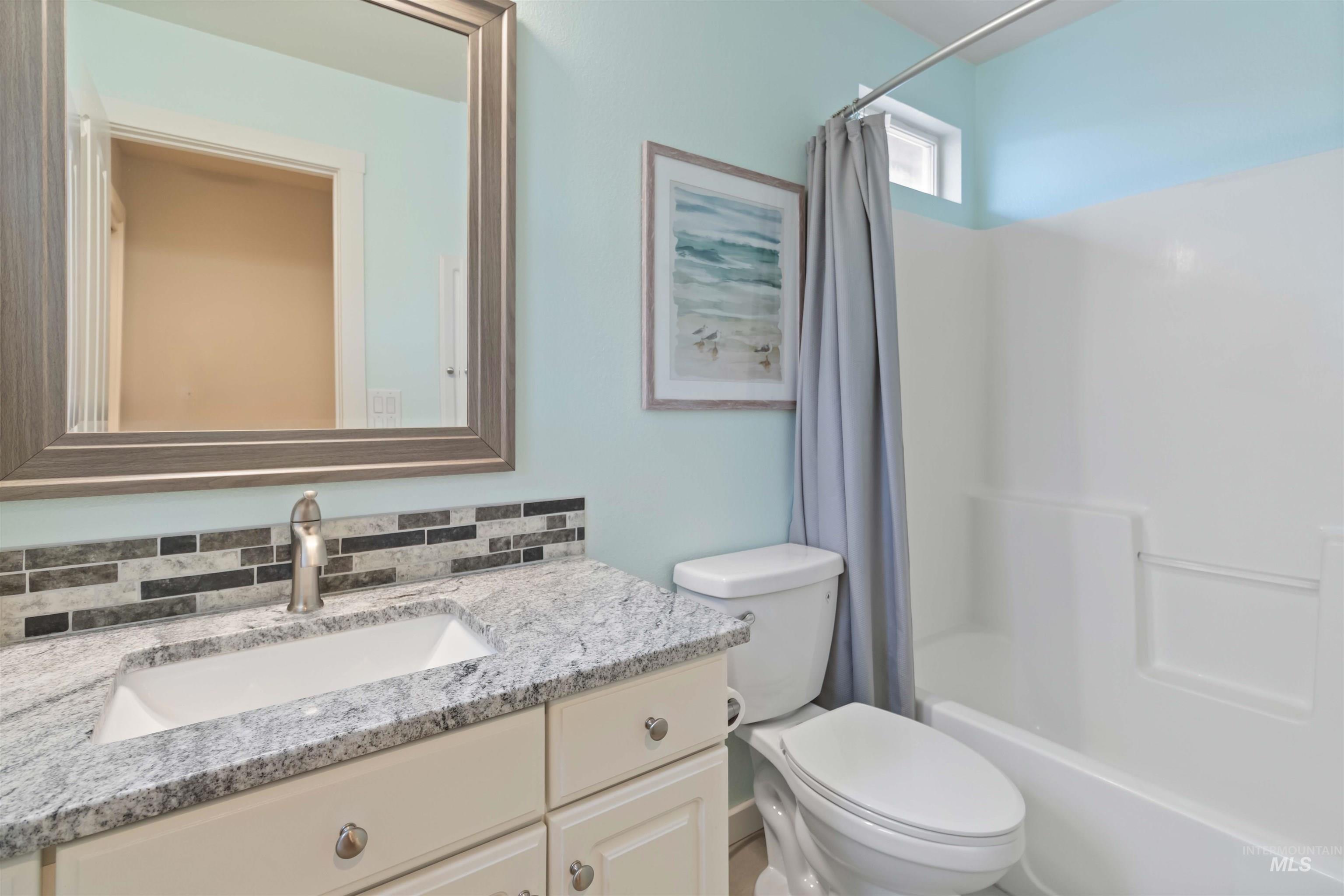 Full bath featuring vanity and shower / tub combo with curtain