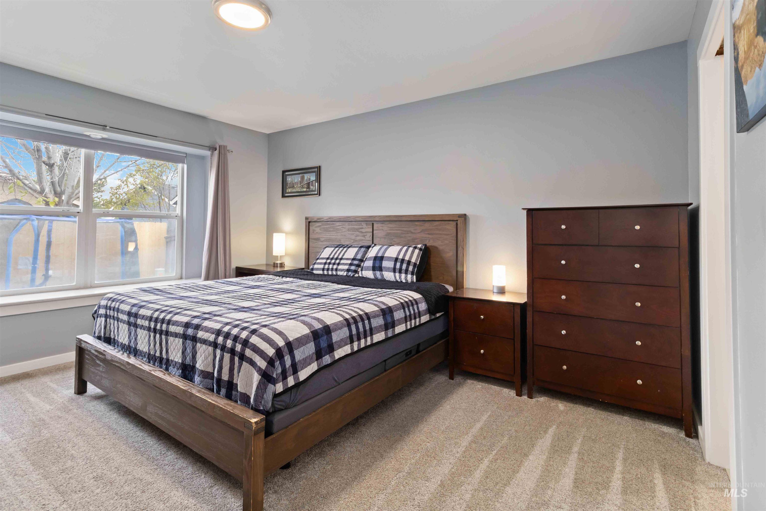 Bedroom with light colored carpet and baseboards