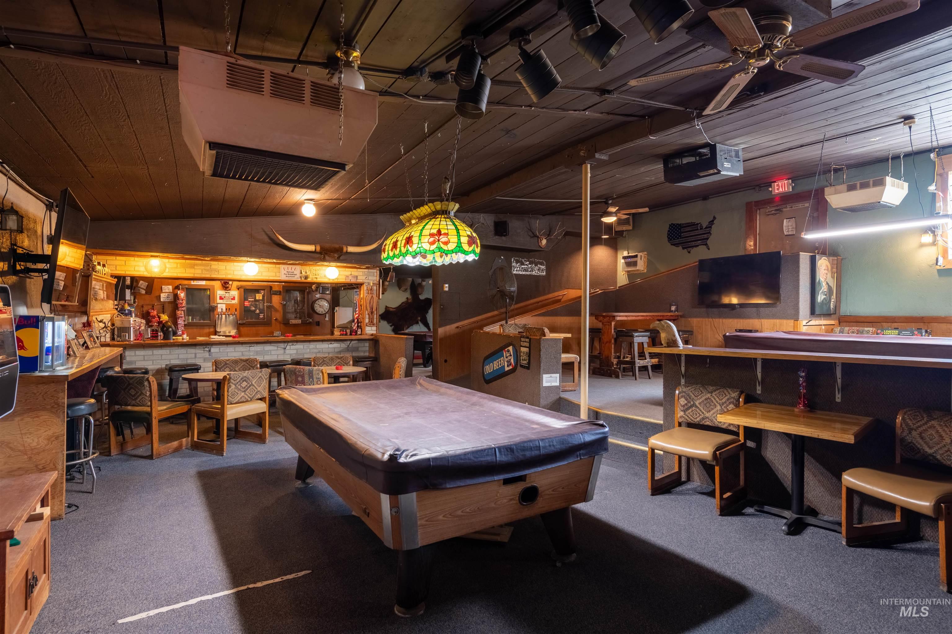 Game room featuring ceiling fan, billiards table, a community bar, carpet, and wood walls
