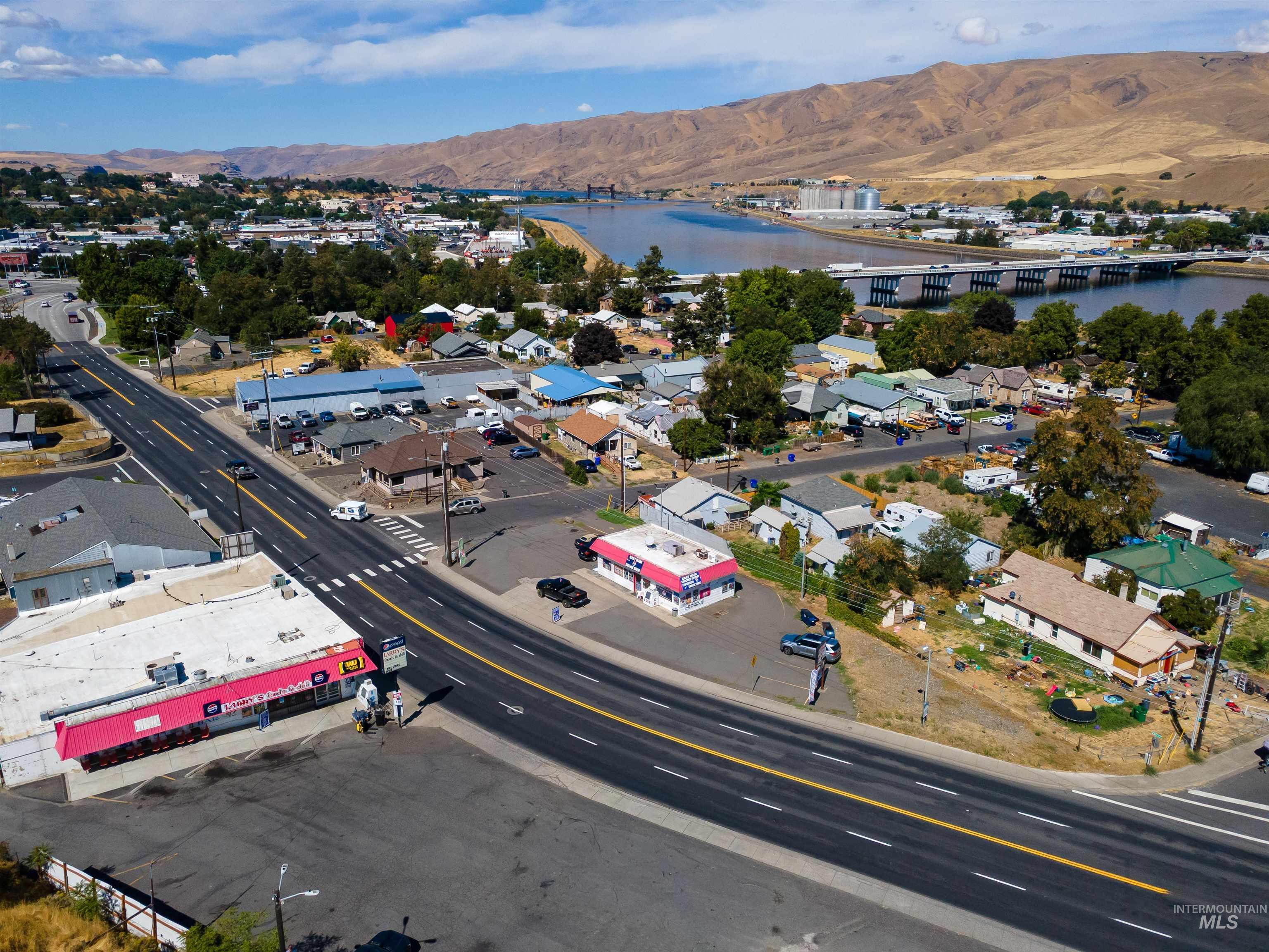 Aerial perspective of suburban area featuring a notable bridge and a water and mountain view