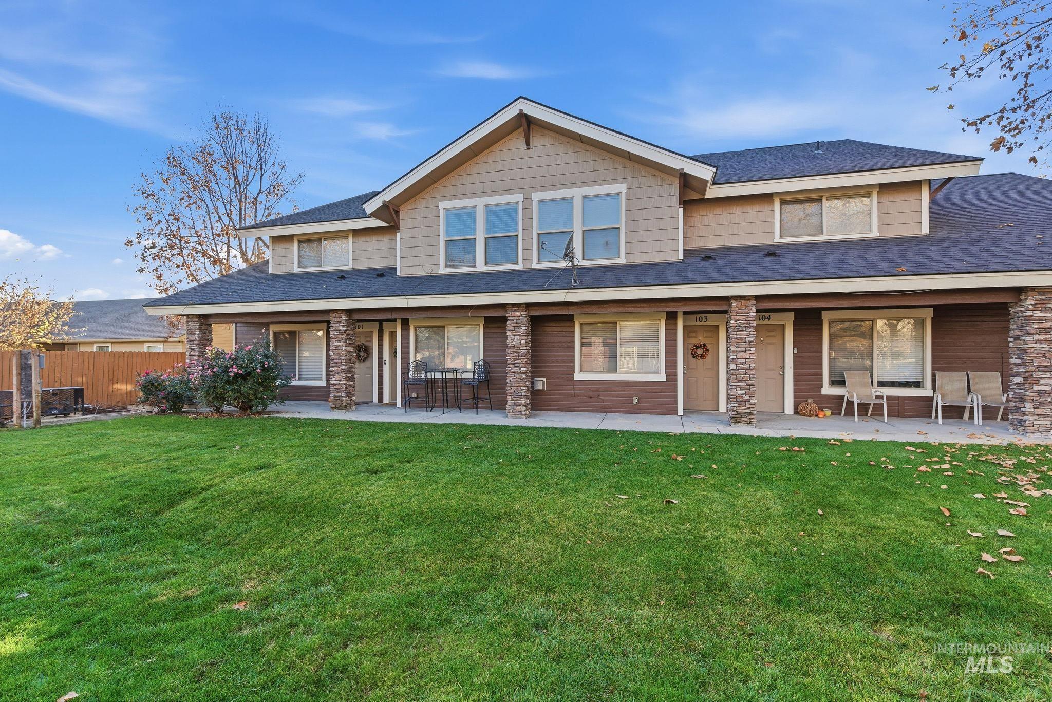 Back of house with a shingled roof and a patio area